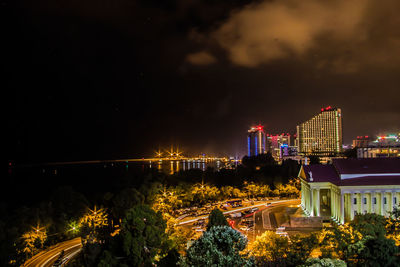 High angle view of river against illuminated buildings