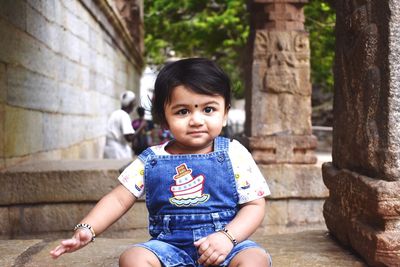 Portrait of cute girl sitting outdoors