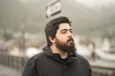 Portrait of young man looking away outdoors