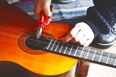 Cropped hand cutting guitar strings