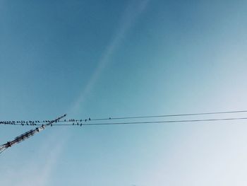 Low angle view of cables against clear blue sky