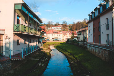 Canal amidst city against sky