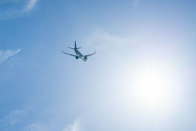 The plane is flying against the blue sky