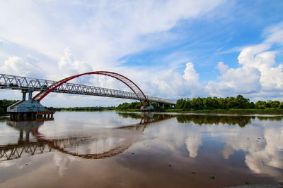 View of bridge over river against cloudy sky