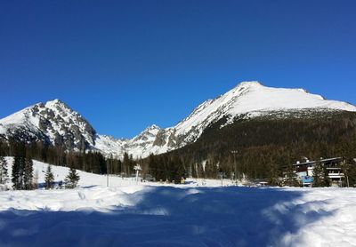 Scenic view of snowcapped mountains against clear blue sky