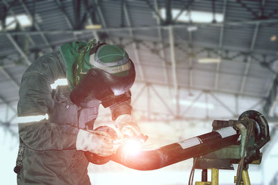 Close-up of man working on metal in factory