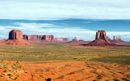 Rock formations on landscape against cloudy sky