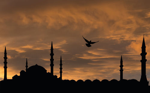 Low angle view of silhouette birds flying against sky during sunset