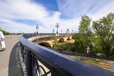 Bridge over road against sky in city