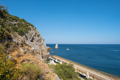 Scenic view of bay against clear blue sky