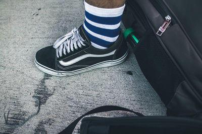 Low section of person wearing shoes standing on road