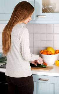 Midsection of woman standing on table at home