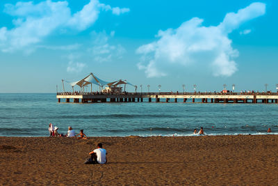 People at beach against sky