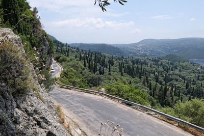 Scenic view of road by mountains against sky