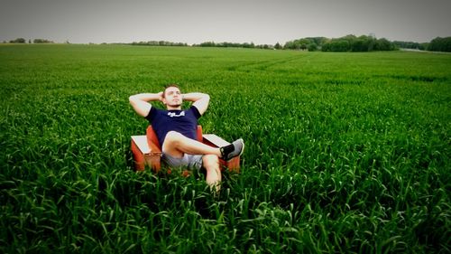 Man sitting in sofa in field