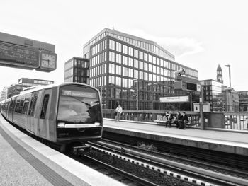 Railroad tracks in city against sky