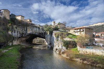 Arch bridge over river against sky