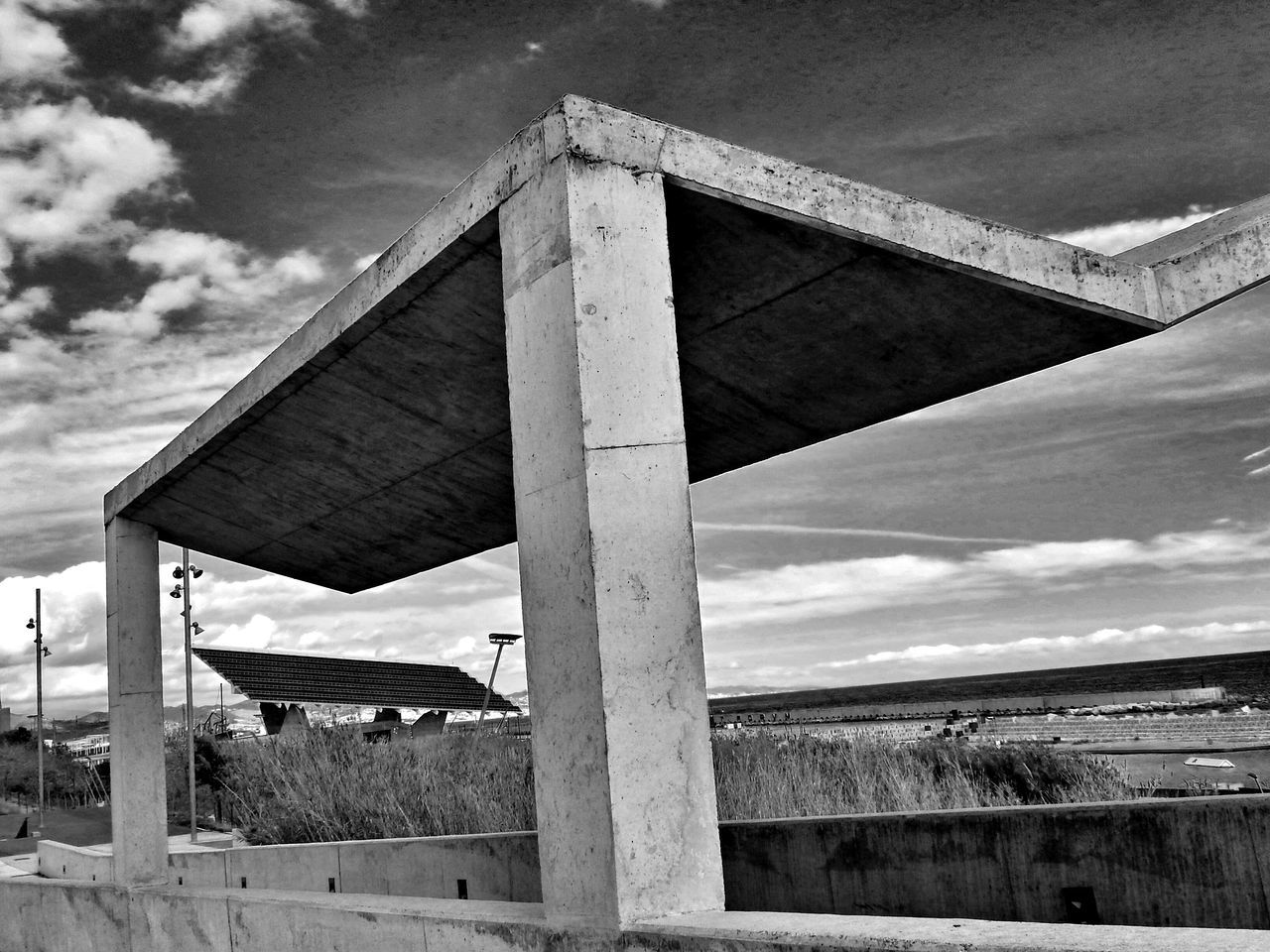 built structure, architecture, sky, cloud - sky, building exterior, cloudy, low angle view, cloud, no people, day, outdoors, old, wood - material, sunlight, architectural column, abandoned, nature, beach, weather, fence