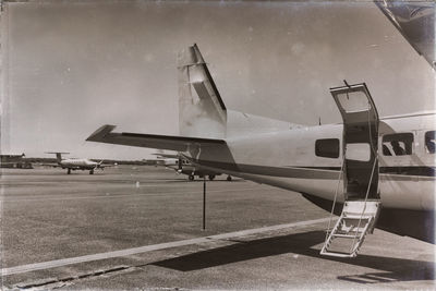 Airplane on airport runway against sky