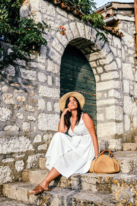 Full length of woman sitting outdoors