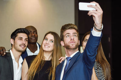 Business colleagues taking selfie with smart phone in office