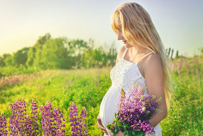 Pregnant woman standing in field