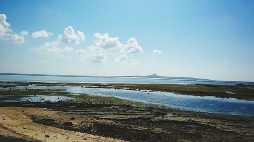 View of calm beach against blue sky