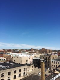 High angle shot of cityscape against blue sky