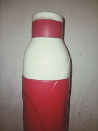 Close-up of red bottle against white background