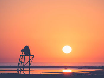 Scenic view of sea against orange sky