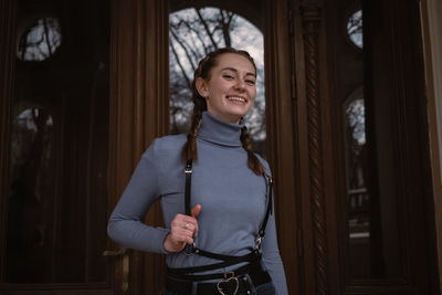 Smiling young woman near door