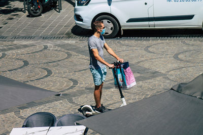 Woman with umbrella on street in city