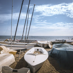 Boats moored on beach against sky