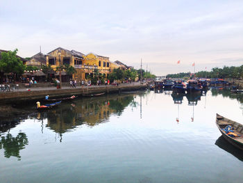 Boats moored in water against sky