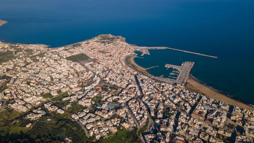 High angle view of townscape by sea against sky