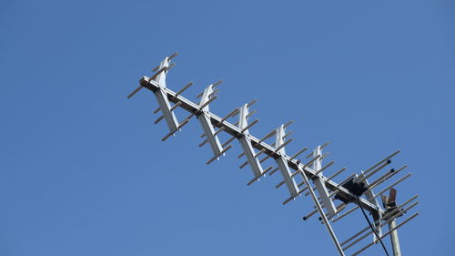 Low angle view of barbed wire against clear blue sky