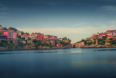 Scenic view of lake by buildings against sky