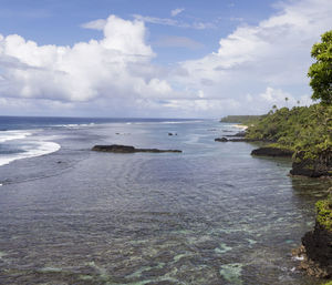 High angle view of fringing reef and shoreline with palm trees