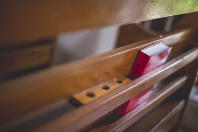 Close-up of red book on wooden shelf