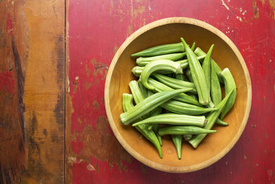 Okra in a bowl on a red table