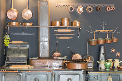 Copper pots and pans and other kitchen utensils in an antique metal kitchen.