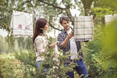 Couple talking while drying laundry in yard