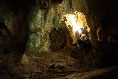 Low angle view of people on rock in cave