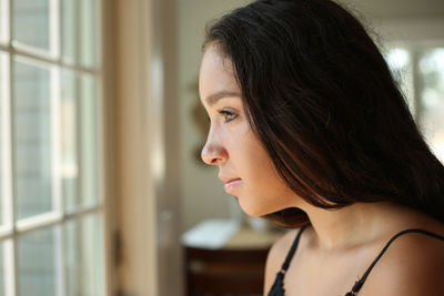 Side view of young woman at home