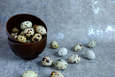 Quail eggs spilling from bowl on marble