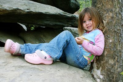 Portrait of girl sitting on rock