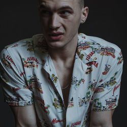 Portrait of man standing against black background