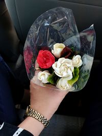 Close-up of hand holding rose bouquet