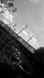 Low angle view of bridge against cloudy sky