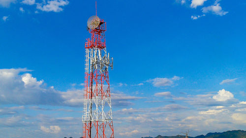 Low angle view of communications tower against blue sky